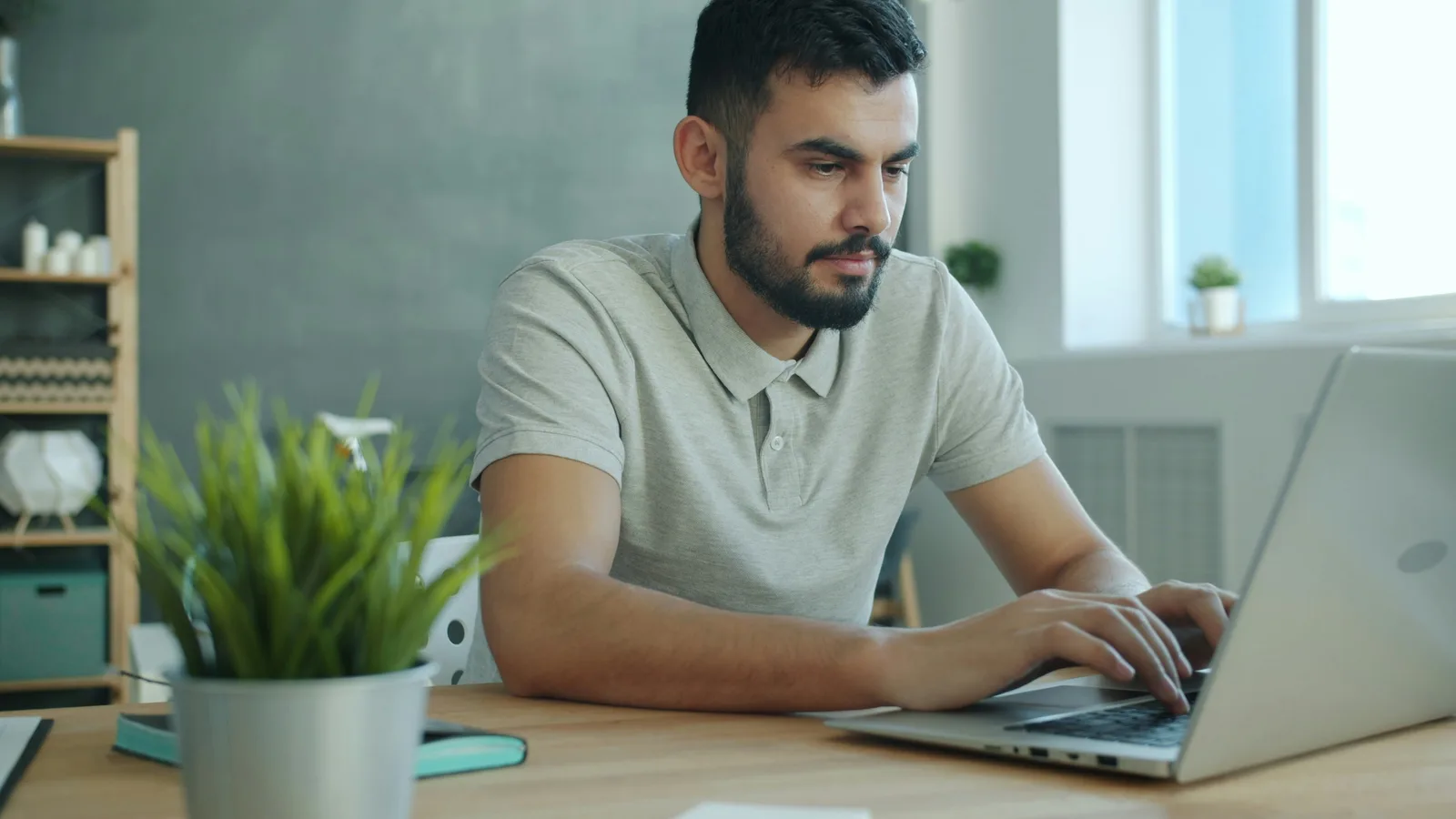 Man typing on a laptop at a desk