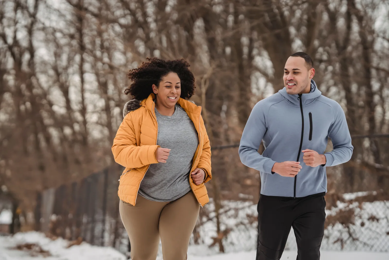 Two adults jogging together outdoors in winter
